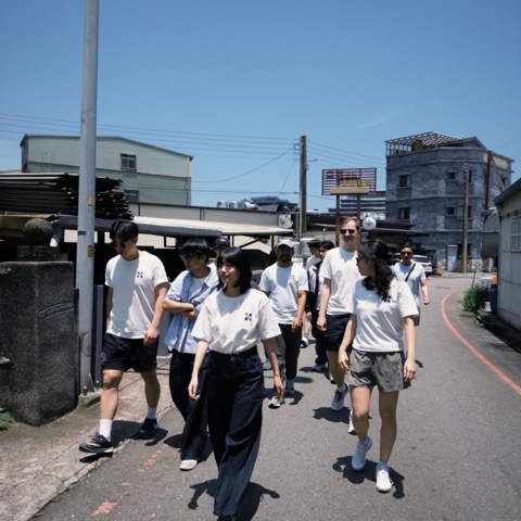 The pebble team walking down a sunlit street in matching shirts